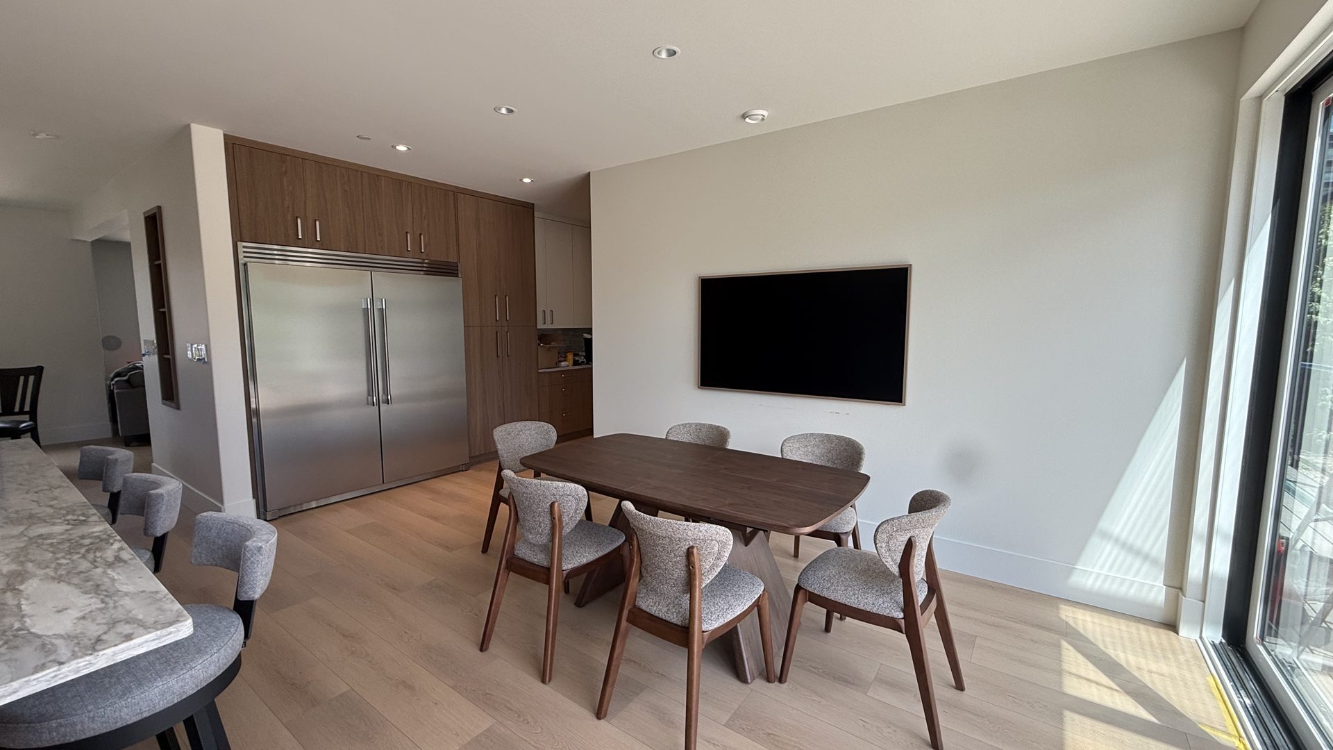 Dining area beside the kitchen with a wood table and large windows